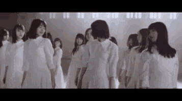 a group of women in white dresses are standing next to each other .