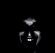 a close up of a person 's face in the dark with a smile on it .