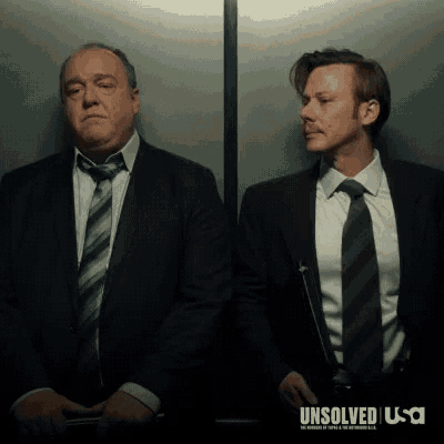 two men in suits and ties are standing next to each other in an elevator with the word unsolved on the bottom