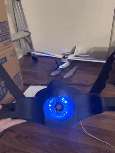 a person holding a black object with a blue light on it