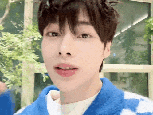 a close up of a person 's face with a blue and white sweater on .