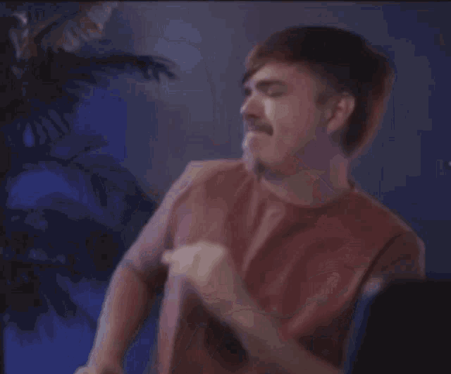 a man with a mustache is dancing in a dark room