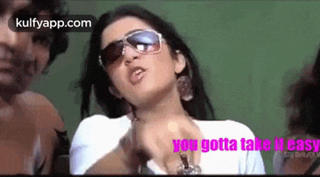 a woman wearing sunglasses and a white shirt is giving a speech .