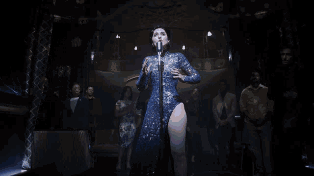 a woman singing into a microphone in front of a crowd