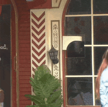 a woman stands in front of a building that has a sign that says ' a ' on it