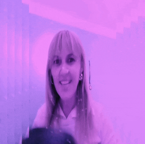 a woman wearing headphones is smiling in front of a pink background .