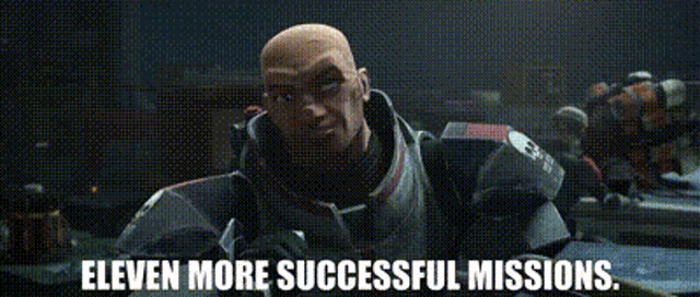 a bald man in a military uniform is standing in front of a group of people and says eleven more successful missions .