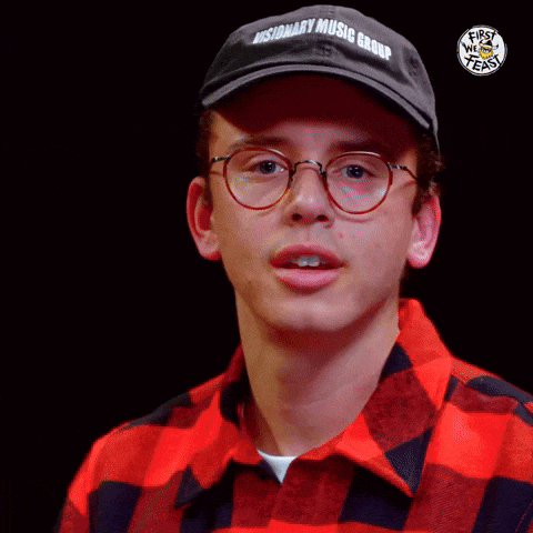 a young man wearing glasses and a plaid shirt is making a funny face .