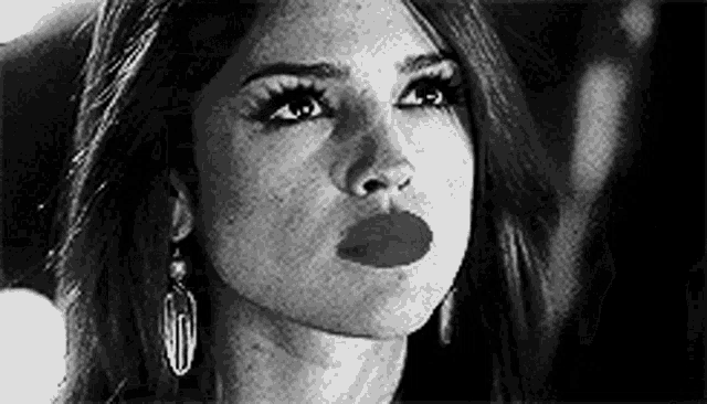 a black and white photo of a woman 's face with a red lip .