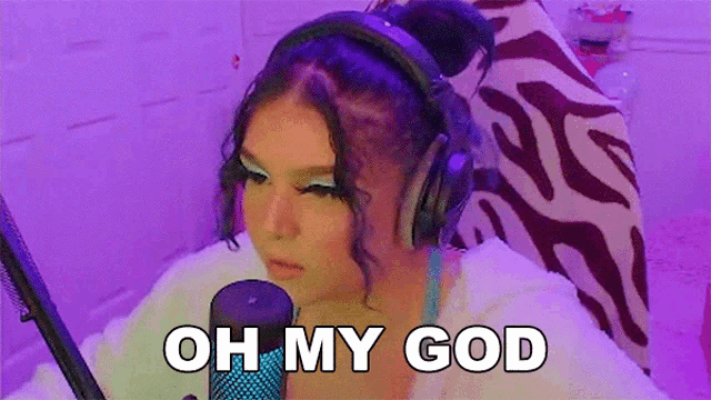 a woman wearing headphones is sitting in front of a microphone and saying oh my god .