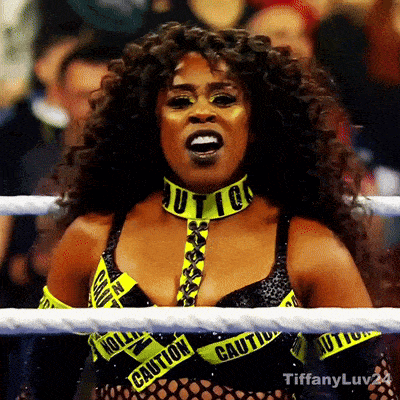 a woman in a wrestling ring wearing a choker that says caution