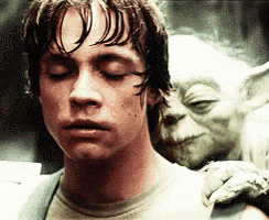 a close up of a man with his eyes closed and a statue of yoda behind him