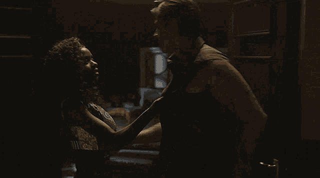 a man holds a woman in his arms in a dark room