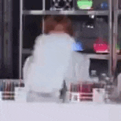a blurry picture of a person standing in front of a cabinet .