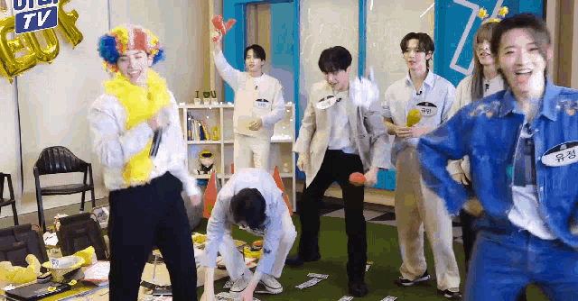 a group of people are dancing in a room with a sign that says ' uiu tv ' on it