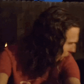 a man with long hair is making a funny face with his mouth wide open