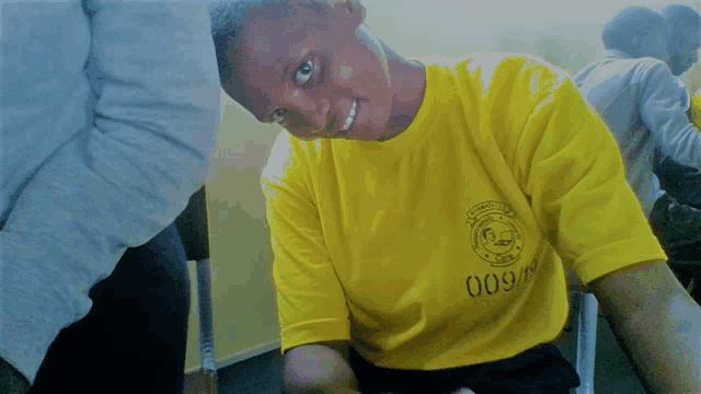 a young man wearing a yellow shirt with the number 009 on it