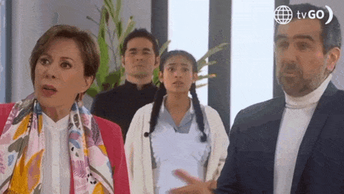 a group of people are standing next to each other in a room with a man in a suit .