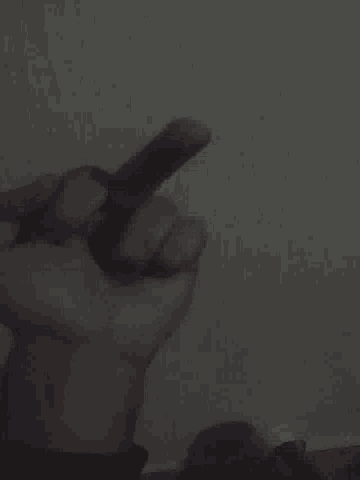 a person 's hand is holding a piece of paper in front of a wall
