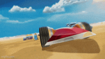 a red and white racing car is driving through the desert .