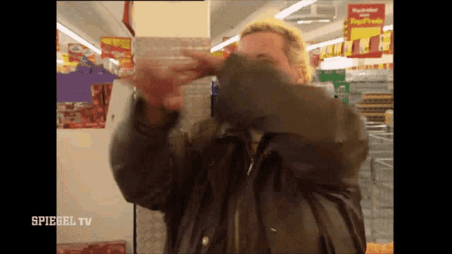 a man covering his face in a store with spiegel tv written on the bottom right