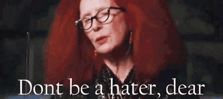 a woman with red hair and glasses is saying do n't be a hater , dear