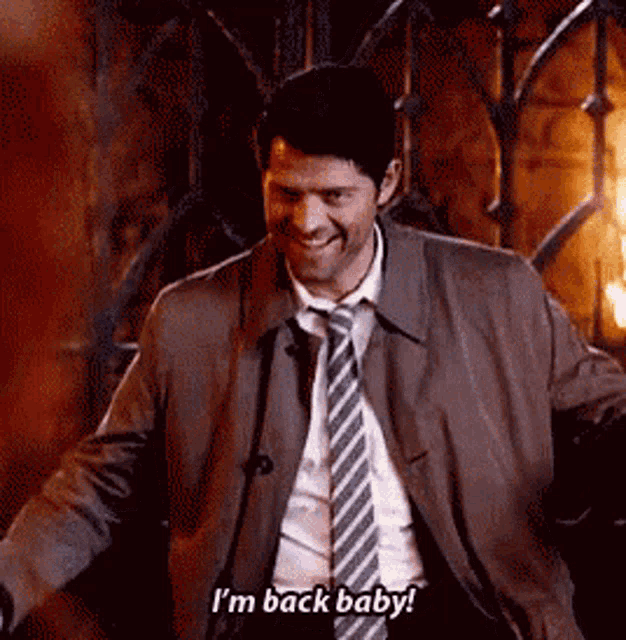 a man in a suit and tie is smiling and saying `` i 'm back baby ! ''