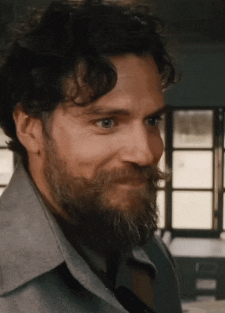 a close up of a man with a beard and curly hair .