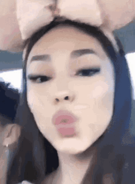 a close up of a woman wearing a minnie mouse headband making a funny face .