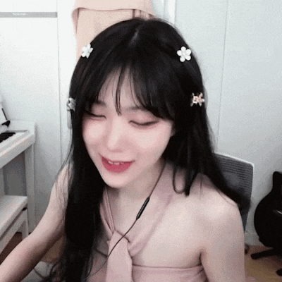 a woman with long black hair and flowers in her hair is sitting in front of a keyboard .