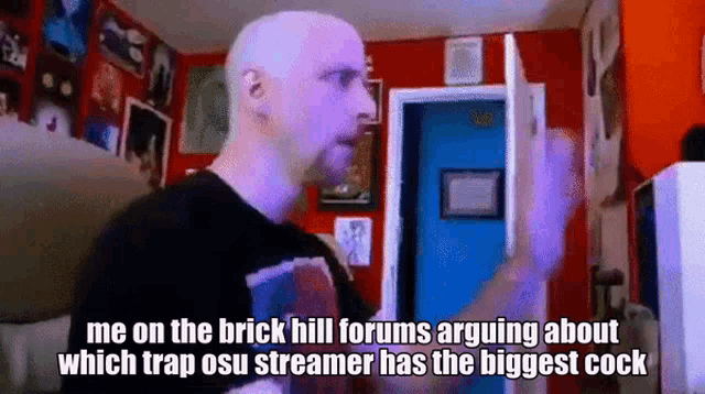 a bald man is standing in front of a blue door and talking about a streamer