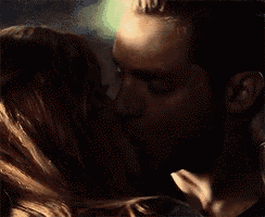 a man and a woman are kissing in the dark