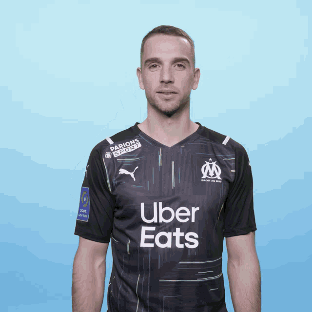 a man wearing a black shirt that says uber eats on it