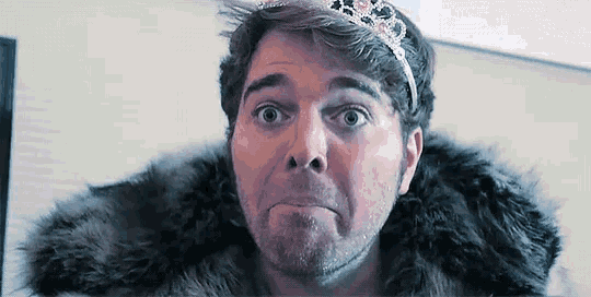 a man wearing a fur coat and a tiara on his head .