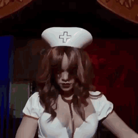 a woman in a nurse costume with a cross on her hat is dancing in a dark room .