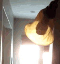 a person is holding a light bulb in a hallway .