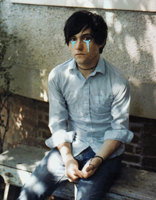a man is sitting on a bench with tears running down his face