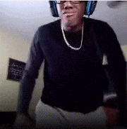 a man wearing headphones and glasses is standing in a room