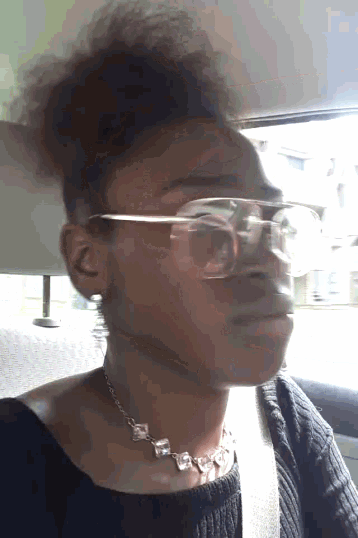 a woman wearing glasses and a necklace looks serious