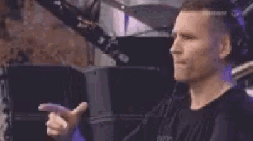 a man in a black shirt is holding a purple object in his hands .