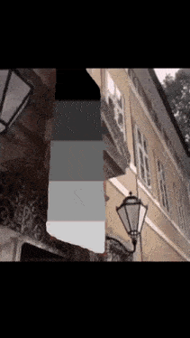 a building with a lamp on the side of it and a sign that says ' a ' on it