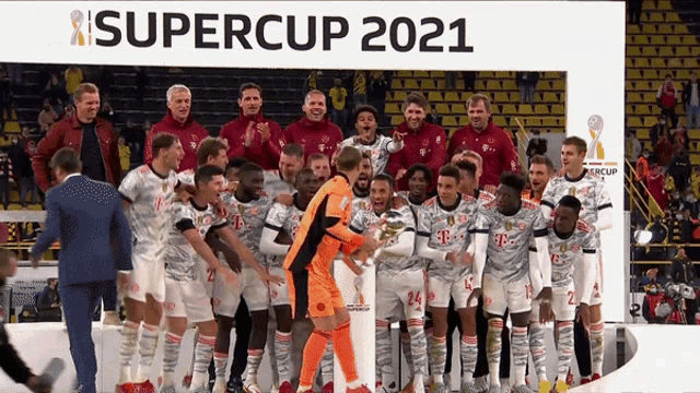 a group of soccer players are posing for a photo in front of a supercup 2021 sign