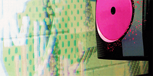 a pink cd with a hole in the middle is sitting on a table .