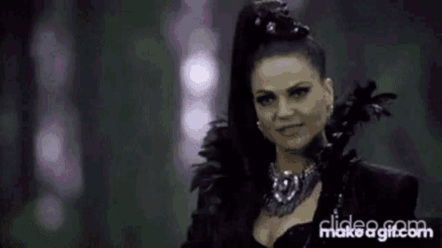 a woman in a black dress and purple feathers is standing in front of a forest .