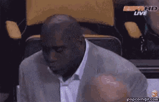 a man in a suit is sitting in a stadium watching a game on espn hd live
