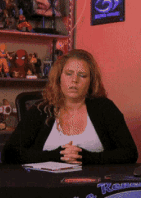 a woman sits at a table with a box that says raven