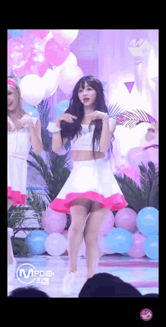 a girl in a pink and white dress is dancing on stage