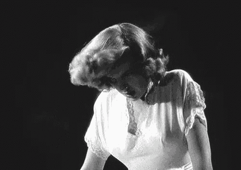 a black and white photo of a woman scratching her head