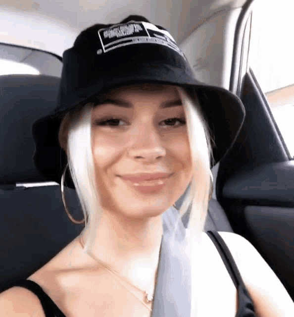 a woman wearing a black bucket hat with the word california on it smiles