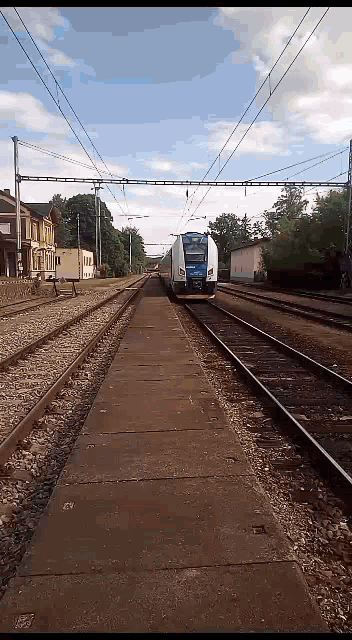 a train going down the tracks with a blue sign on the front